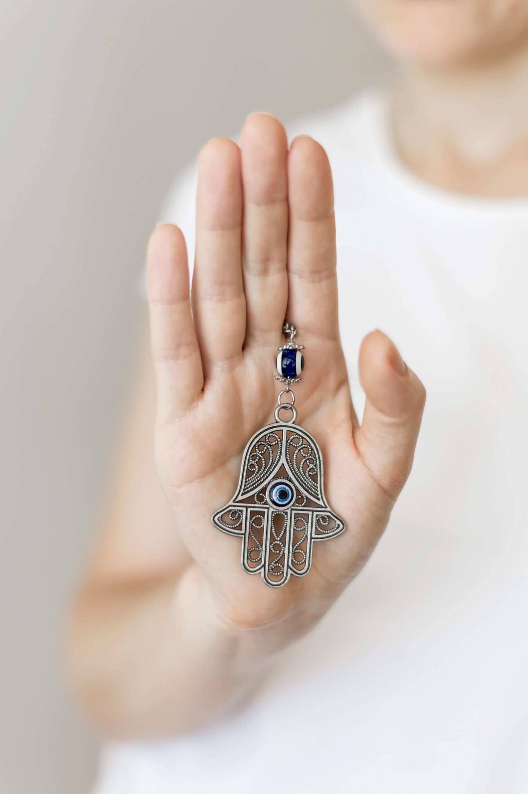 front view person holding hamsa pendant hand